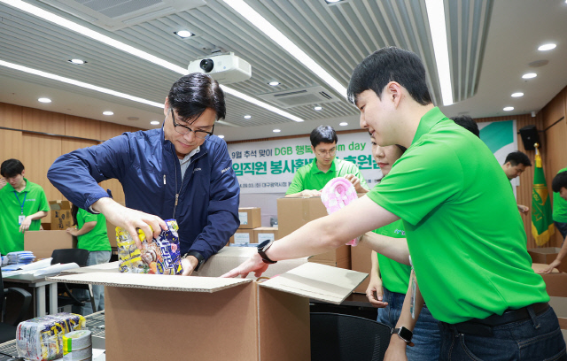 DGB금융지주 그룹가치경영총괄 성태문 전무(왼쪽)와 DGB봉사단 단원들이 생필품 박스를 포장하고 있다. [DGB금융그룹 제공]